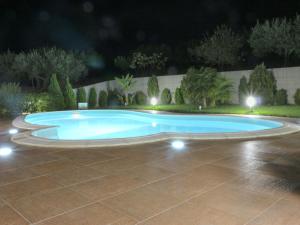 a swimming pool in a yard at night at Belvilla by OYO Villa Rita in Buseto Palizzolo