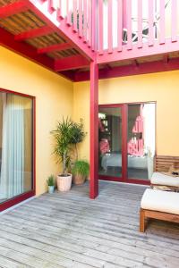 a patio with a deck with a pink railing at Cestaria Costa Nova in Costa Nova