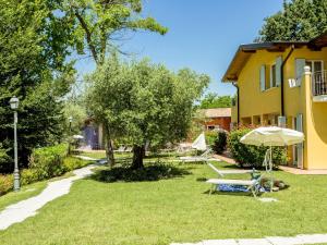 podwórko ze stołem, parasolem i domem w obiekcie Belvilla by OYO Cozy Holiday Home with barbecue w mieście Polpenazze del Garda