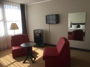 a hotel room with two chairs and a table and a bed at Hotel Wörth in Wörth an der Isar
