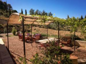 a gazebo with chairs and a table in a garden at Stylish villa with swimming pool in Fraissé-des-Corbières