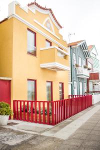 una valla roja frente a un edificio en Cestaria Costa Nova en Costa Nova