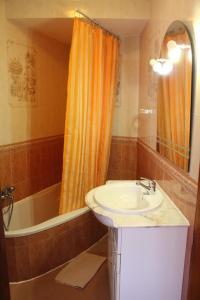 a bathroom with a sink and an orange shower curtain at Sagres Sunny Room with private bathroom 300m from the beach in Sagres +33 photos