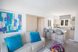ein Wohnzimmer mit einem weißen Sofa und blauen Kissen in der Unterkunft Evelina Apartment in Protaras