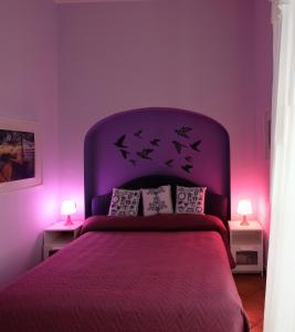 a purple bedroom with a bed with a purple headboard at Casa Miranda in Vico Equense