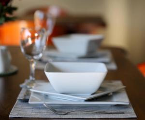 une table en bois avec des assiettes et des verres blancs dans l'établissement Marjaniek Wedding Venue & Guest House, à Rietfontein