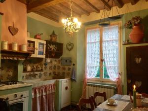 une cuisine avec une table et une cuisinière ainsi qu'une fenêtre dans l'établissement La casa del cuore, à Stazzema