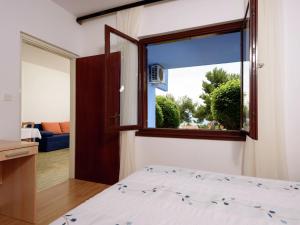 a bedroom with a bed and a large window at Apartment Medena in Trogir