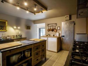 a large kitchen with a stove and a refrigerator at Luxurious Holiday Home with Sauna in Alveringem in Leisele