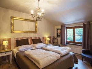 a bedroom with two beds and a mirror on the wall at Luxurious Holiday Home with Sauna in Alveringem in Leisele