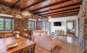 a living room with a wooden table and chairs at Avrofilito Syros Houses in Ermoupoli