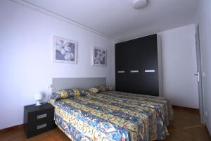 a bedroom with a bed and a black cabinet at Residencial Super Stop Palafrugell in Palafrugell
