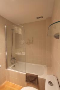 a bathroom with a shower and a toilet and a tub at Residencial Super Stop Palafrugell in Palafrugell