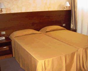 a bedroom with a bed with a wooden head board at Hostiliae Ciminiera Hotel in Ostiglia