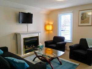 a living room with a fireplace and a tv at Ellis House Bed & Breakfast in Niagara Falls