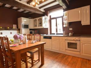 a kitchen with a wooden table and a wooden floor at Spacious holiday home in Teuven with garden in Teuven