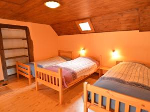 two twin beds in a room with wooden ceilings at Spacious holiday home in Teuven with garden in Teuven