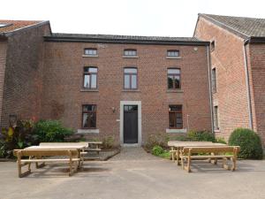 a brick building with picnic tables in front of it at Spacious holiday home in Teuven with garden in Teuven