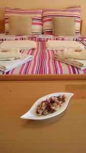 ein Teller mit Essen auf einem Tisch neben einem Bett in der Unterkunft Osterija Na Planinci in Divača