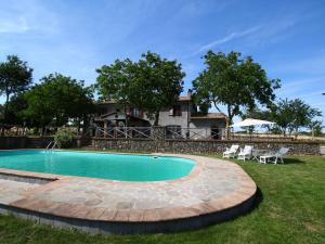 バニョレージョにあるSpacious Farmhouse in Bagnoregio with Swimming Poolの家屋を背景にした庭のスイミングプール