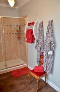 łazienka z prysznicem i czerwonym krzesłem w obiekcie La Minaudière 62 w mieście Boulogne-sur-Mer