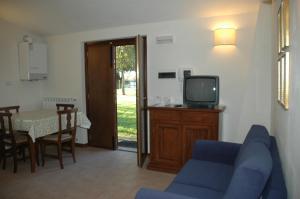 a living room with a blue couch and a tv at Residenza Torre Acquatino in Spello