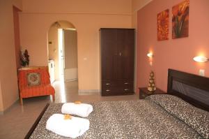 a bedroom with a bed with two towels on it at Athina Studios in Argasi