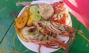 a plate of food with seafood and vegetables on a table at Cabaña Luna Azul in Playa Blanca