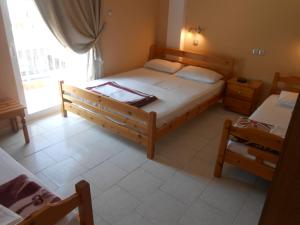 a bedroom with a large bed and a window at Hotel Germany in Paralia Katerinis