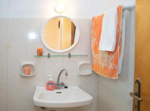 a bathroom with a sink and a mirror and towels at Athina Studios in Argasi