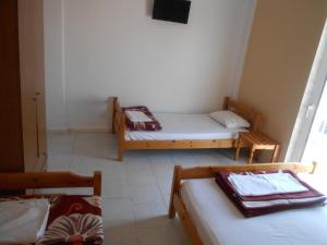 ein kleines Zimmer mit 2 Betten und einem Fenster in der Unterkunft Hotel Germany in Paralia Katerinis