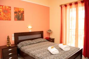 a bedroom with a bed with two towels on it at Athina Studios in Argasi