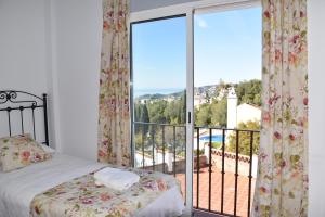 una camera da letto con un letto e una grande finestra di Villa Pelae a Frigiliana Altre 278 foto