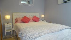 1 dormitorio con 1 cama grande con almohadas rojas en Cosy Caleta Apartment, en Cádiz