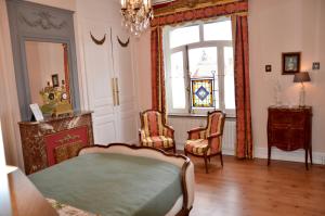 sypialnia z łóżkiem, 2 krzesłami i oknem w obiekcie La Minaudière 62 w mieście Boulogne-sur-Mer