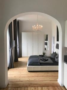 Un dormitorio con una cama grande y una lámpara de araña. en Schloss Grabow, Resting Place & a Luxury Piano Collection Resort, Prignitz Brandenburg en Grabow