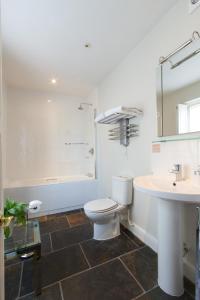 a white bathroom with a toilet and a sink at The Old Vine in Winchester