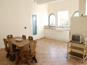 eine Küche mit einem Tisch und einem TV in der Unterkunft Modern Apartment in Trecase with garden in Trecase