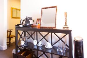 a shelf with a mirror and glasses on it at The Old Vine in Winchester