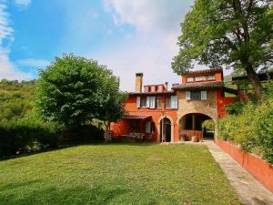 ファブリアーノにあるCozy Villa in Fabriano Italy with Swimming Poolの広い芝生の庭がある大きなオレンジの家