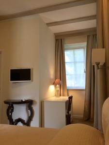 una camera con letto, finestra e lampada di Relais Torre Dei Torti - Luxury Bed and Breakfast a Cava Manara