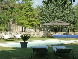 a swimming pool with chairs and a gazebo at Detached villa with enclosed beautiful garden in Reillanne
