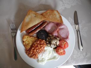 a plate of breakfast food with eggs sausage beans and toast at Maryland Bed and Breakfast in Bridlington