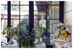 una camera con finestra con piante e frutta di Relais Torre Dei Torti - Luxury Bed and Breakfast a Cava Manara