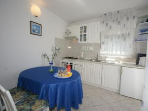 a kitchen with a table with a blue table cloth on it at Neat apartment in Vinisce with magnificent sea and beach within walking distance in Vinišće