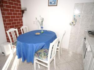 a blue table with chairs and a vase on it at Neat apartment in Vinisce with magnificent sea and beach within walking distance in Vinišće