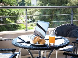 een tafel met een laptop en brood en een glas sinaasappelsap bij Topfloor comfortable luxury apartment in Dubrovnik