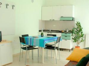 ヴェルバーニアにあるApartment in a residence on Lake Maggiore near the beachのキッチン(青いテーブル、椅子付)