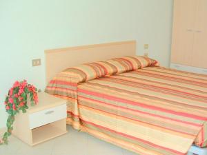 ヴェルバーニアにあるApartment in a residence on Lake Maggiore near the beachのベッドルーム1室(ストライプのベッドカバー付)