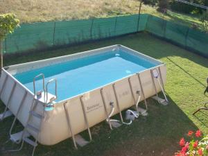 a swimming pool in a yard with two chairs around it at Comfortable and quiet apartment in Istria with privacy in Šajini